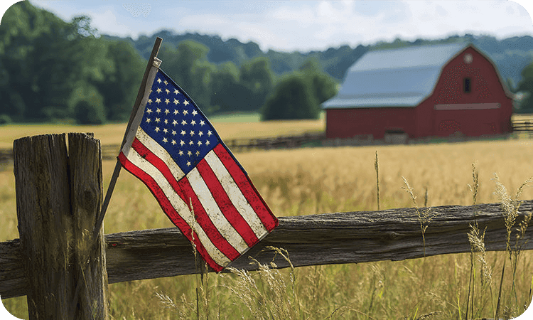 American flag on a wooden fence with a red barn in the background