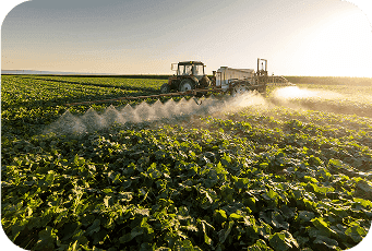 Tractor spraying fertilizers over crops enabled by ag loan
